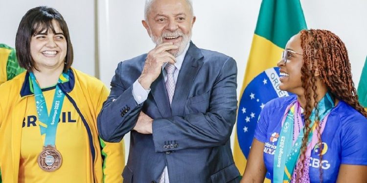 O presidente Lula entre Bruna Alexandre, primeira atleta paralímpica do Brasil a disputar Jogos Pan-Americanos entre os olímpicos, e a campeã mundial e olímpica Rebeca Andrade. Foto: Ricardo Stuckert / PR